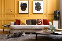 Pet cat in modern living room with yellow painted panelled walls 