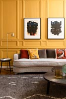 Sofa in front of colourful yellow wall