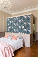 Floral wallpaper on feature wall behind bed in classic bedroom 