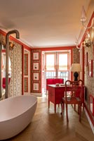 Desk and chair in eclectic red bathroom 