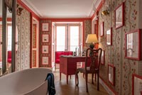 Desk and chair in eclectic red bathroom 