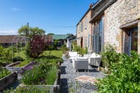 Outdoor seating area on gravel terrace of country house 