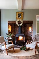 Lit wood burning stove in country living room at Christmas time 