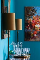 Pair of lamps on sideboard in modern dining room with blue painted walls 