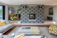 Grey patterned feature wall in centre of modern open plan living space 