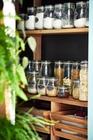Storage jars on wooden shelving in pantry 