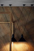 Black metal pendant lamps next to wooden wall 