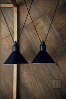 Black metal pendant lamps next to wooden wall 