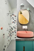 Teal and pink sink unit against concrete wall in modern bathroom 