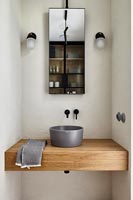 Grey bathroom sink on large wooden shelf