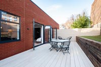 Modern house and decking area with table and chairs 