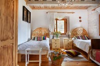 Twin beds with decorative wooden carved headboards in country bedroom 