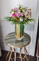 Vase of flowers on small side table with marble top 