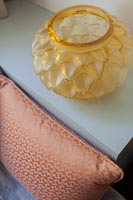 Ornate orange glassware next to patterned pillow - detail 