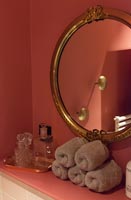 Gilded round mirror on bathroom wall - detail 
