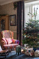 Colourfully patterned armchair next to Christmas tree 