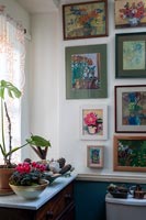 Display of framed floral paintings on bathroom wall 