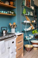 Aga style stove in modern kitchen with teal blue painted walls 