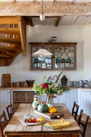 Country kitchen-diner with units under staircase 
