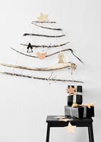 Black and white gifts on table under wall mounted twig tree 