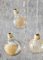 Lightbulb baubles decorated with gold glitter 