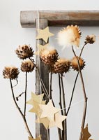 Gold stars tied around branches of drying flowers for Christmas 