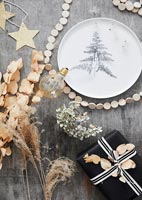 Black, white and gold Christmas display on wooden dining table 