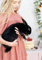Young woman holding pet rabbit 