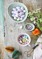 Chocolate Easter eggs in bowls on wooden table 
