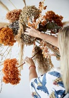 Woman creating a dried flower arrangement 