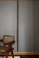 Wooden chair next to panelled wall 