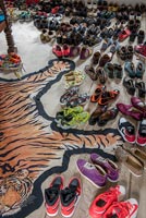 Floor filled with shoes and a tiger rug 