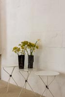 Black vases of flowers on white table 