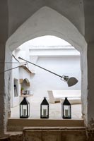 Lamp and lanterns on floor with arch above 