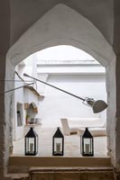 Lamp and lanterns on floor with arch above 