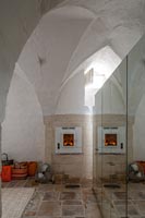 Lit fire set into stone wall with vaulted ceilings 