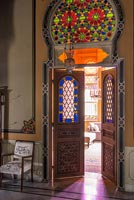 Ornate stained glass window over internal double doors