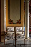 Painted wall behind two chairs in classic hallway 