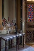 Ornate painted wall panels and console table in classic hallway 