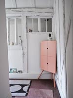 Modern pink corner cabinet in country hallway 