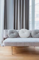 Modern pale grey sofa with round cushions 