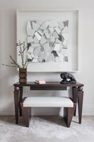 Unusual wooden table with stool - textured artwork on wall above 
