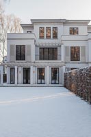 Exterior of classic house with snow covered garden in winter 
