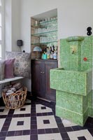 Green tiled water feature next to drinks cabinet 