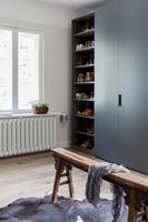 Dark grey wardrobes with rows of shoes on shelves 