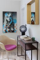 Modern desk and chair with large artwork on wall 