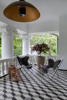 seating area on modern balcony with black and white illusion flooring 