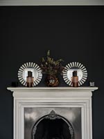 White and silver fireplace next to black wall 
