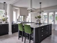 Green barstools by large black kitchen island 