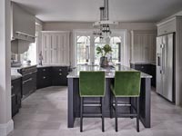 Green barstools by large black kitchen island 